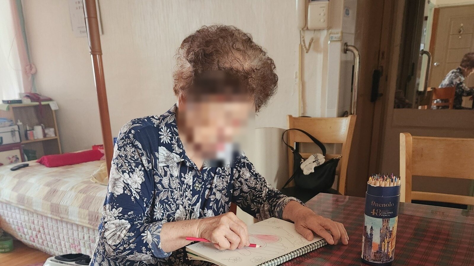 노트에 색연필로 기록하며 인지 활동을 하는 어르신